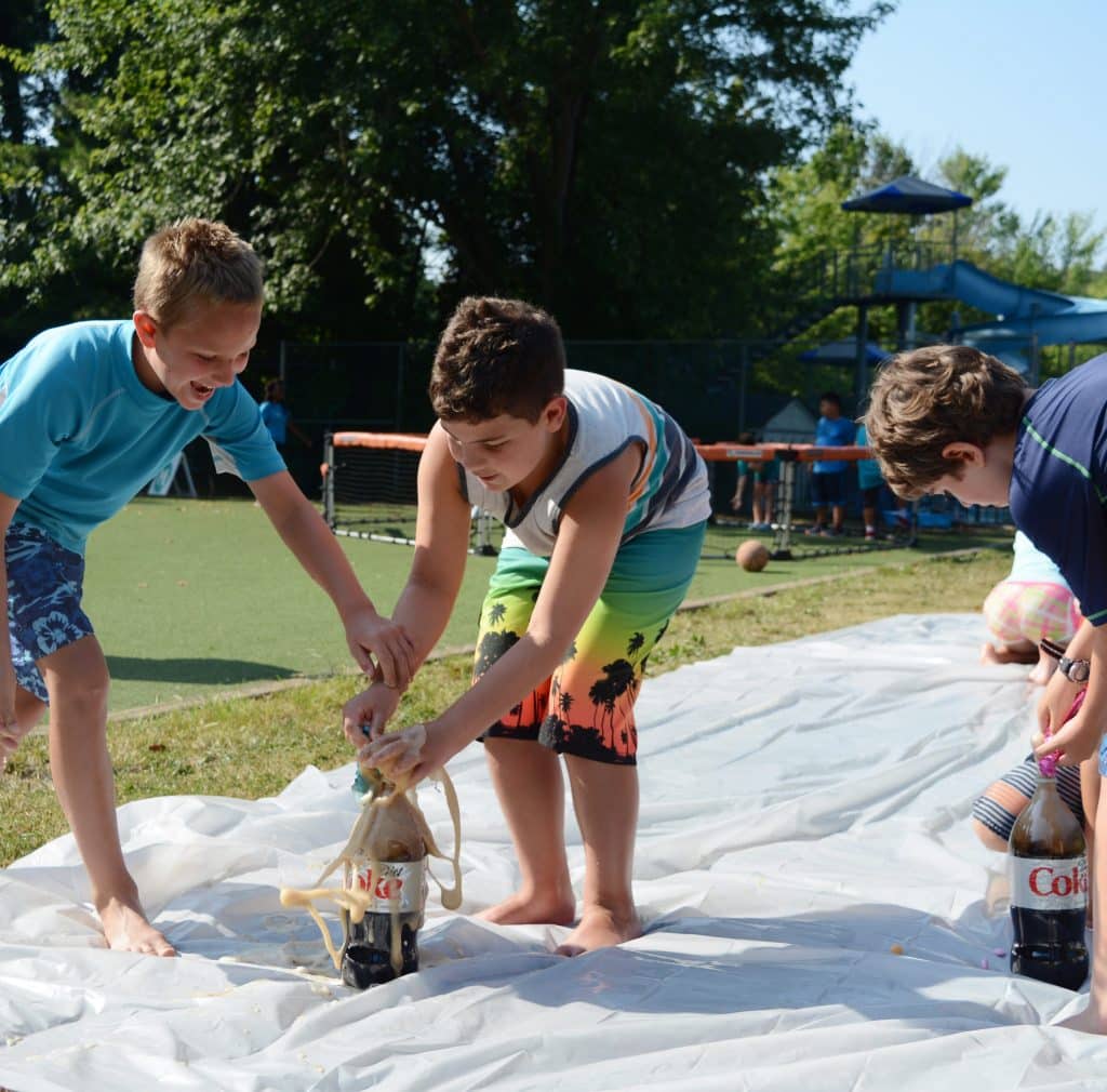 Boys doing science fun science experiment outdoors.