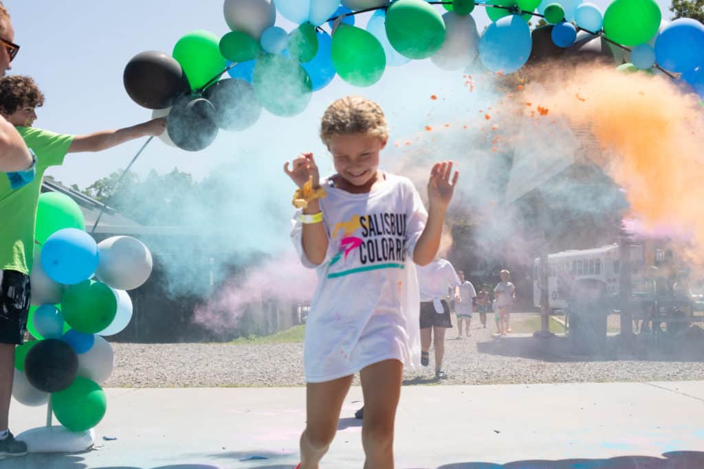 Young girl smiling while participating in a color run.
