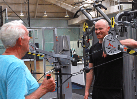 Two men talking by workout equipment