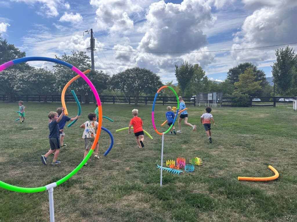 campers and counselors playing quidditch in the grass  